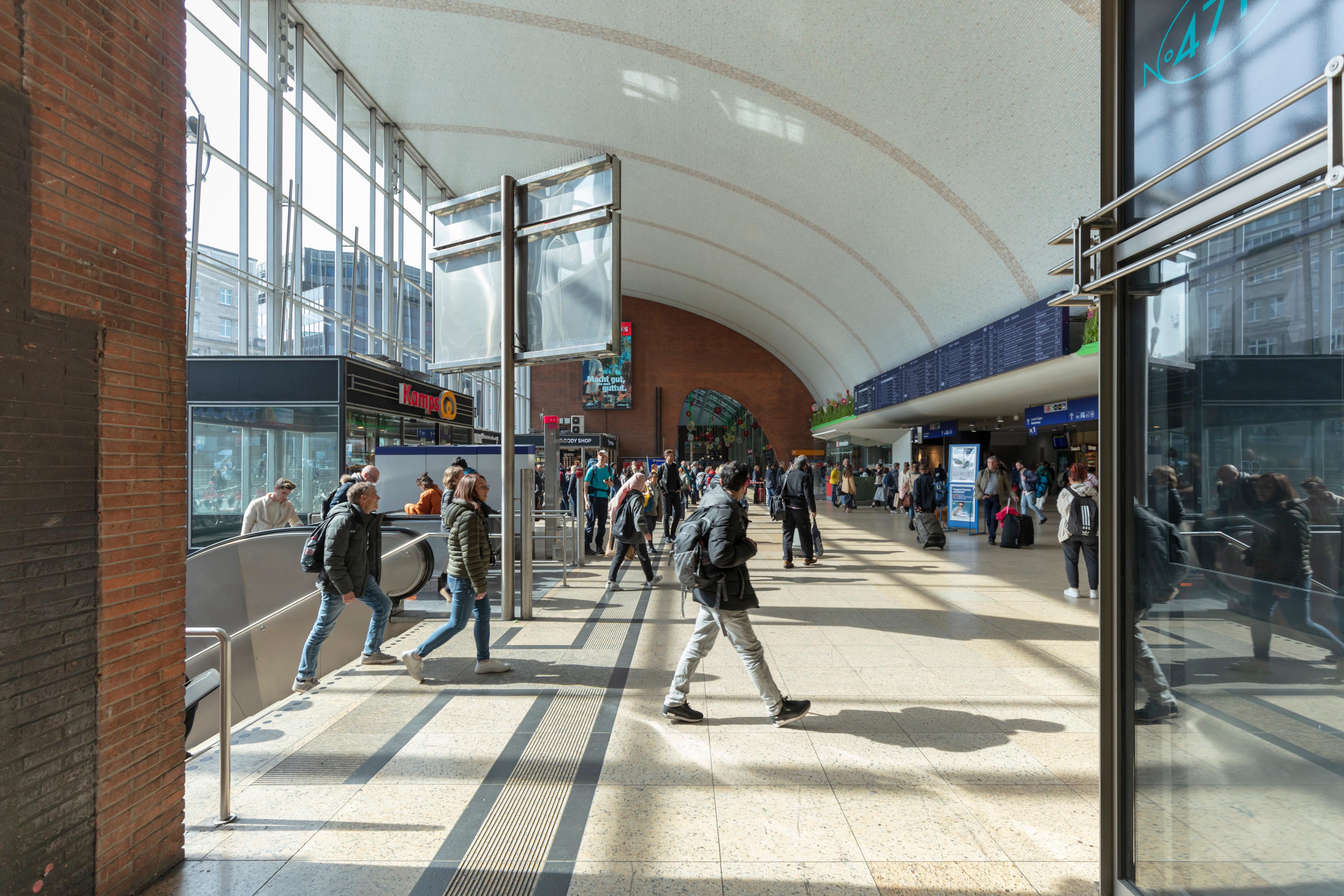 Numerous travellers and visitors pass through the reception hall of Köln Hauptbahnhof.