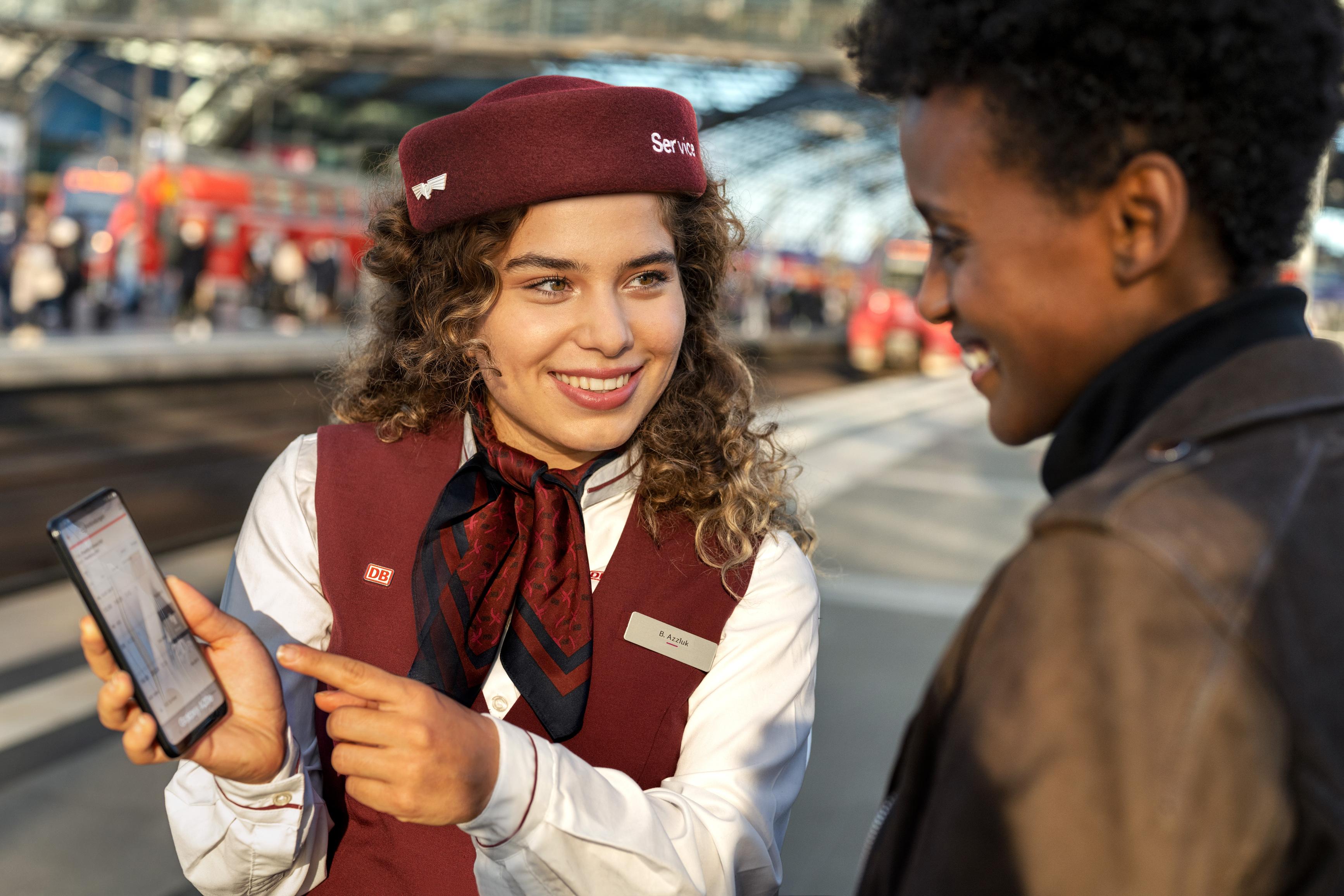 A DB employee advises a passenger on the platform at Berlin Central Station.