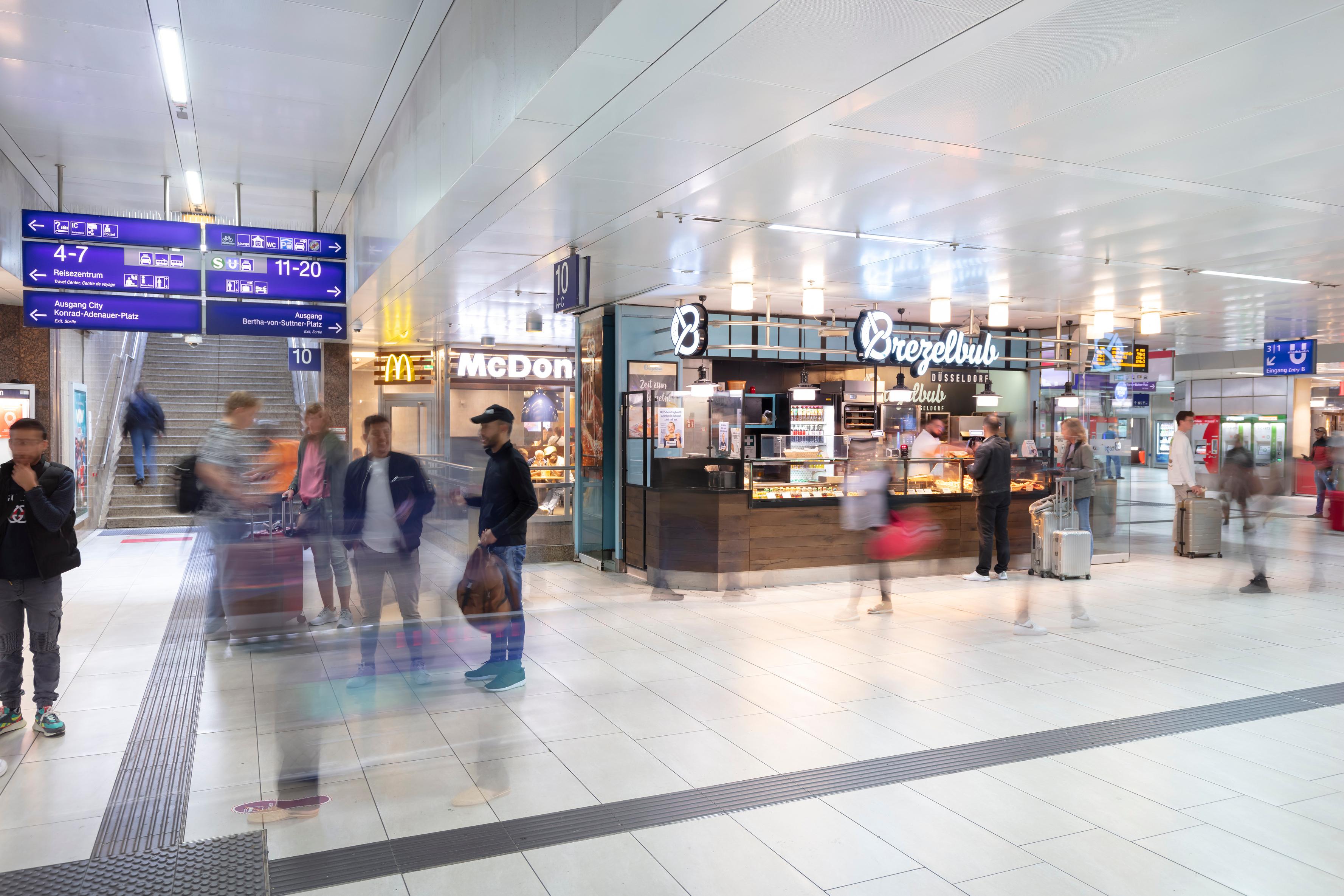 Personen spazieren durch den Düsseldorfer Hauptbahnhof.