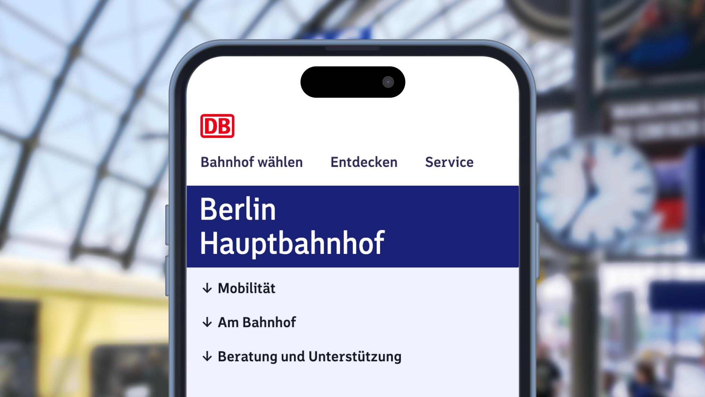 Vor dem Hintergrund eines Bahnsteiges mit einer haltenden S-Bahn wird ein Smartphone mit der geöffneten Bahnhofsseite Berlin Hauptbahnhof gezeigt.	