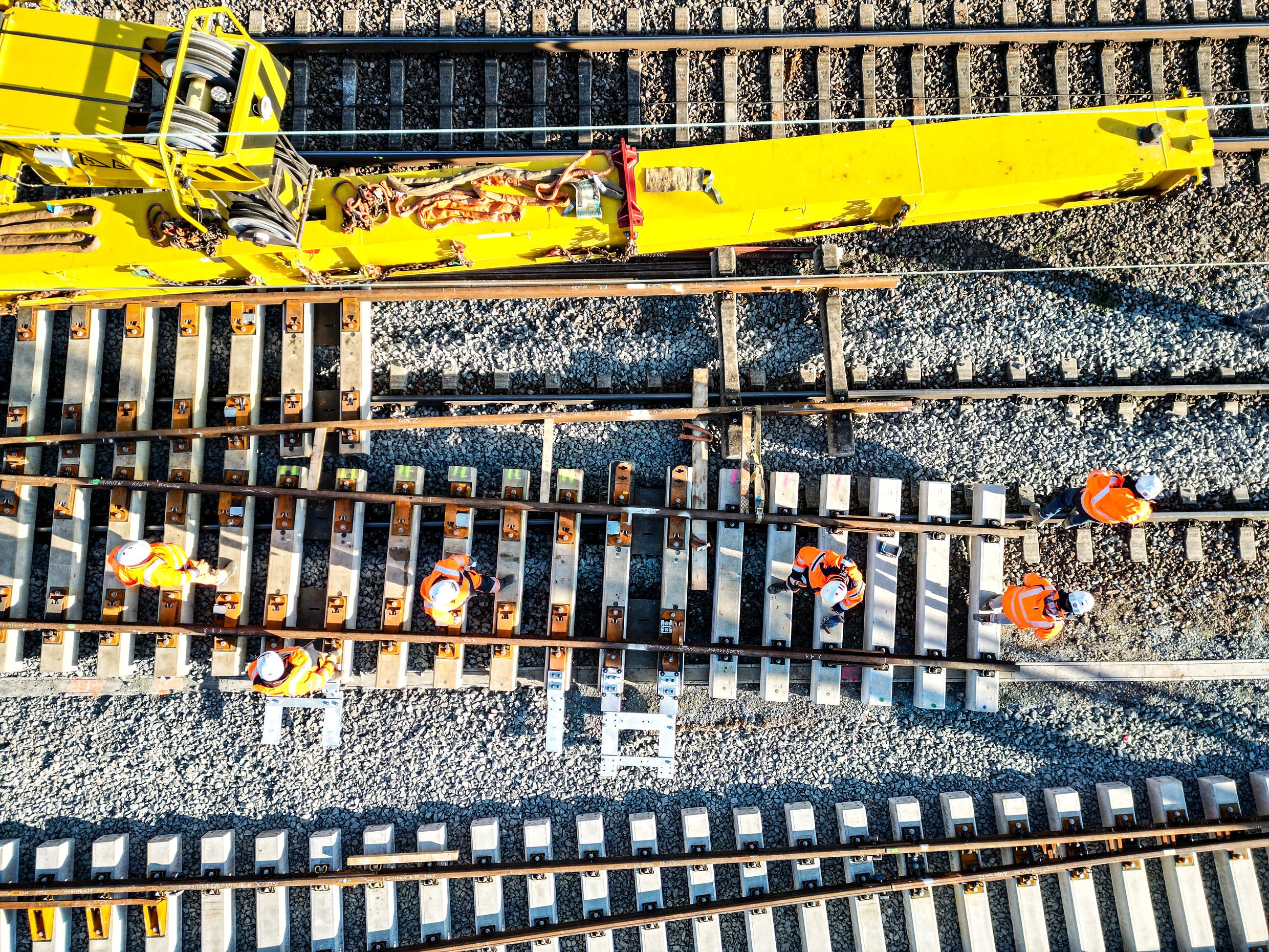 A yellow slewing railway crane during track construction work in Mannheim.